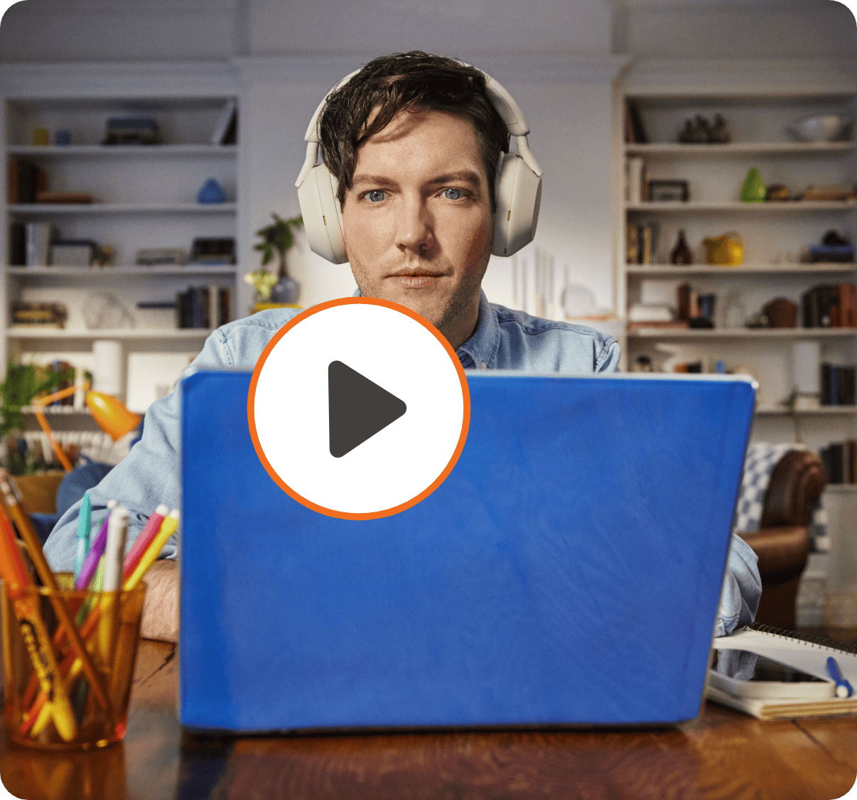 Man looks down at his laptop in a home workspace with the word work superimposed over him.