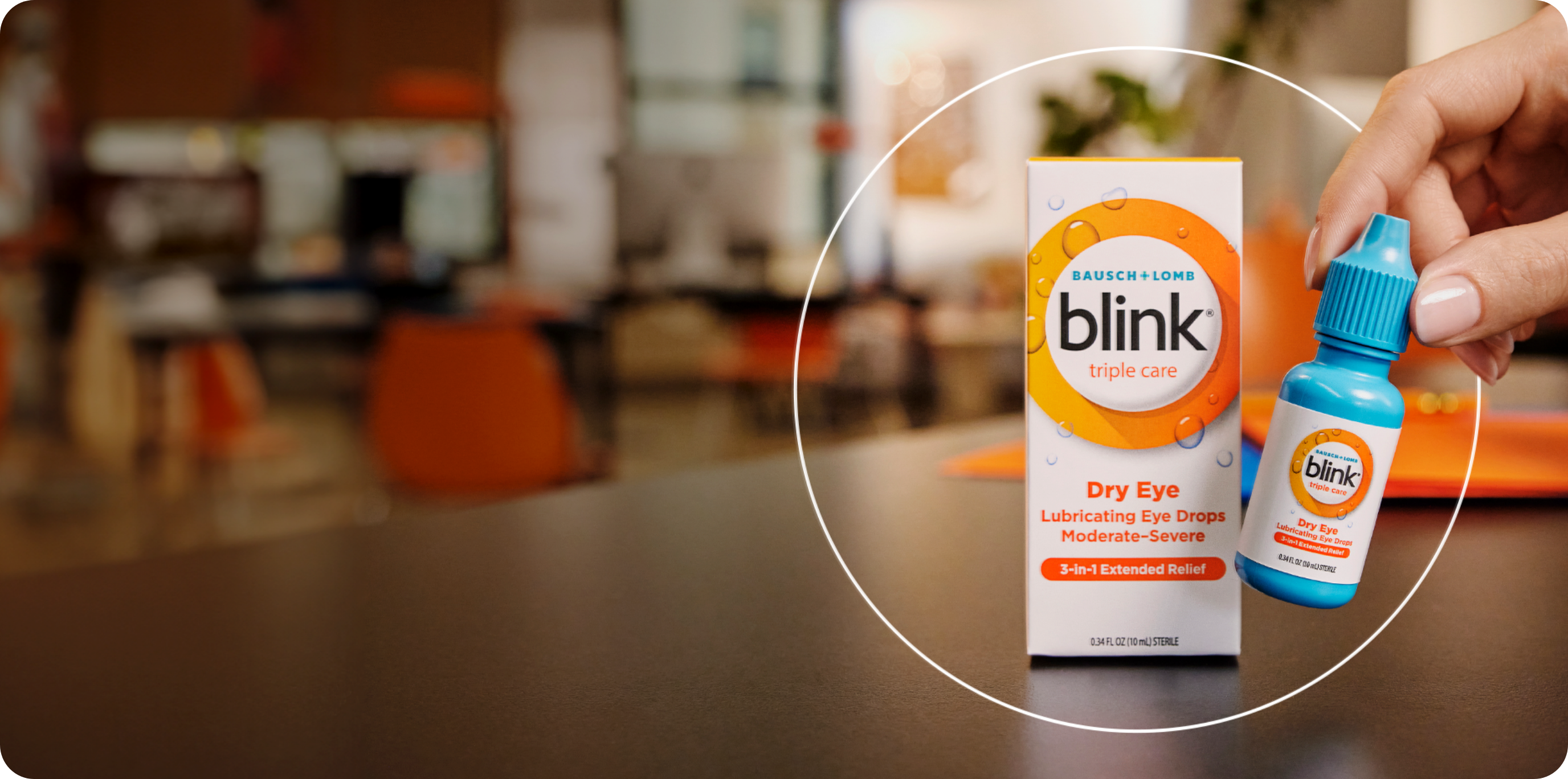 Blink Triple Care Lubricating Eye Drops package on a table with an individual bottle being picked by a hand