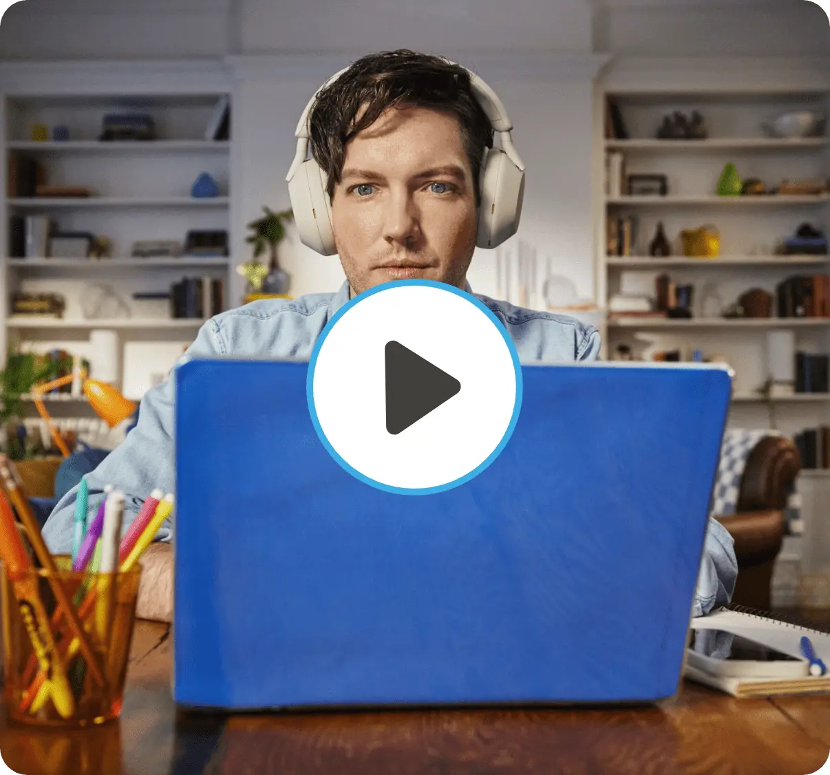 Man looks down at his laptop in a home workspace with the word work superimposed over him.