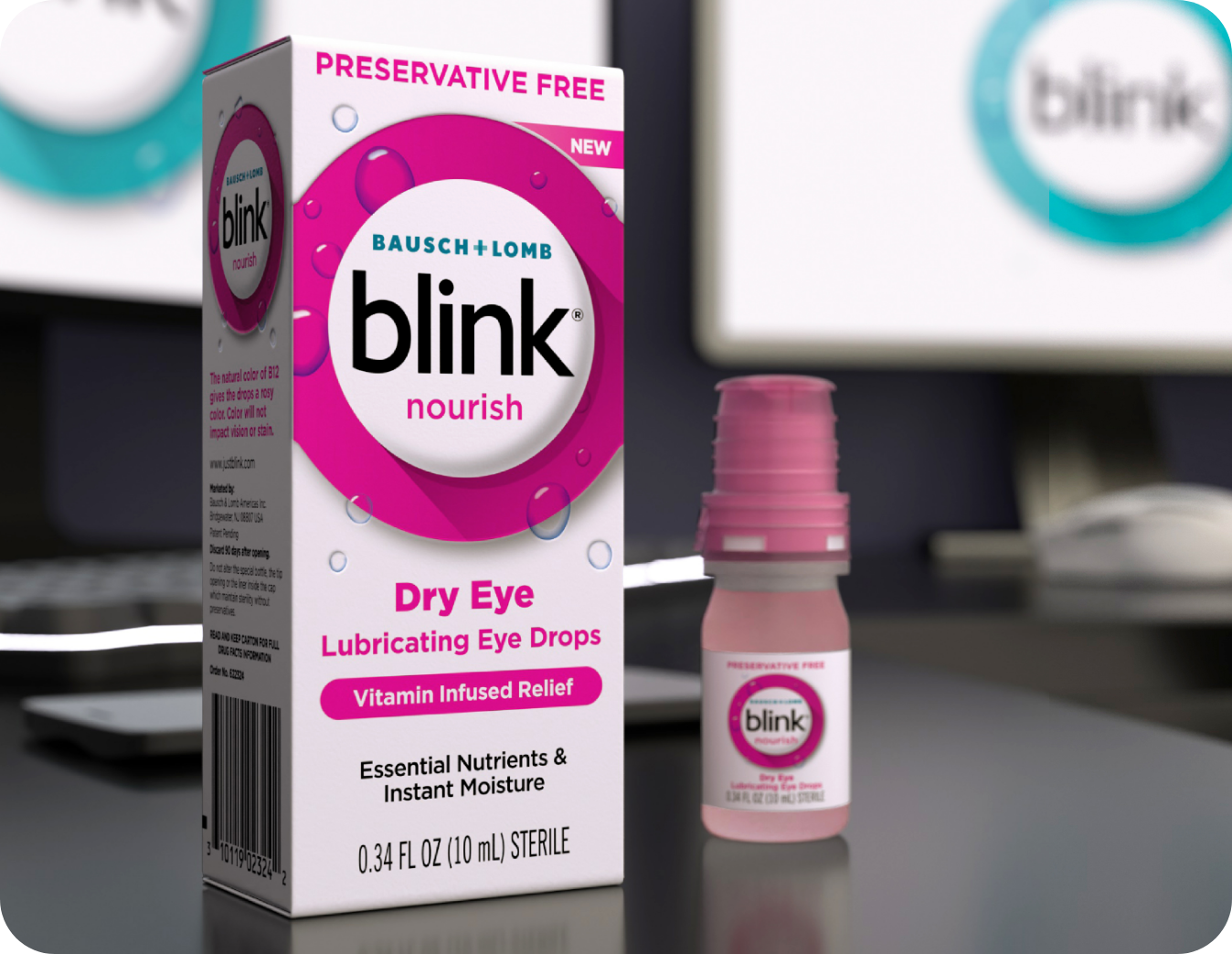 Blink Nourish Lubricating Eye Drops bottle and carton on a desk in front of a computer monitor